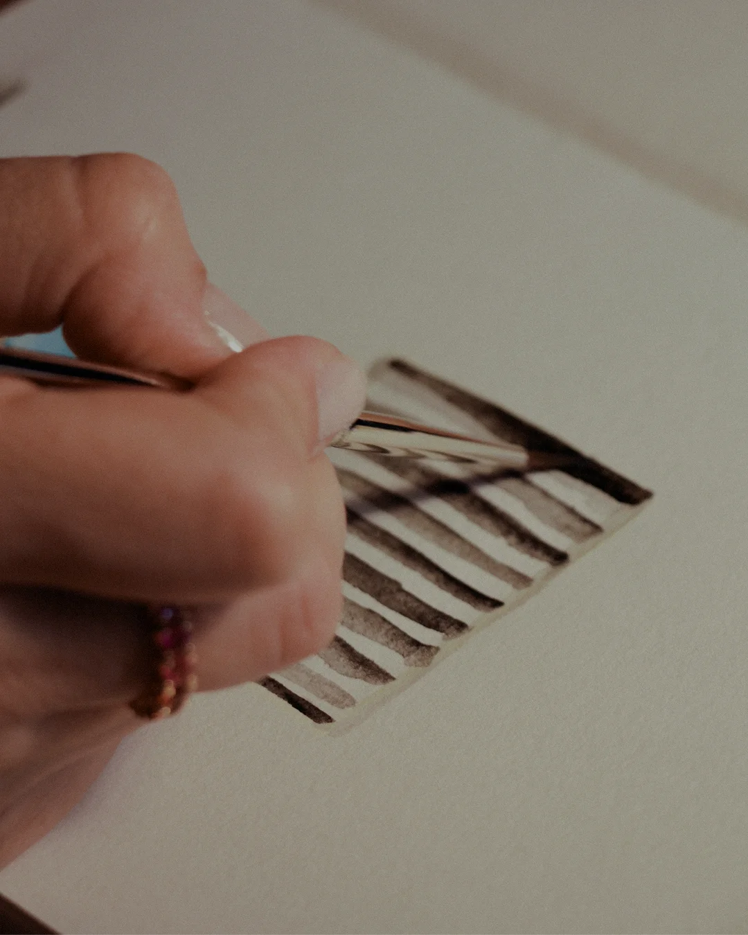 Alice Ceiling Lamp with sculptural brass structure, delicate porcelain accents, and luxurious fabric lampshade, casting warm light in elegant interiors.