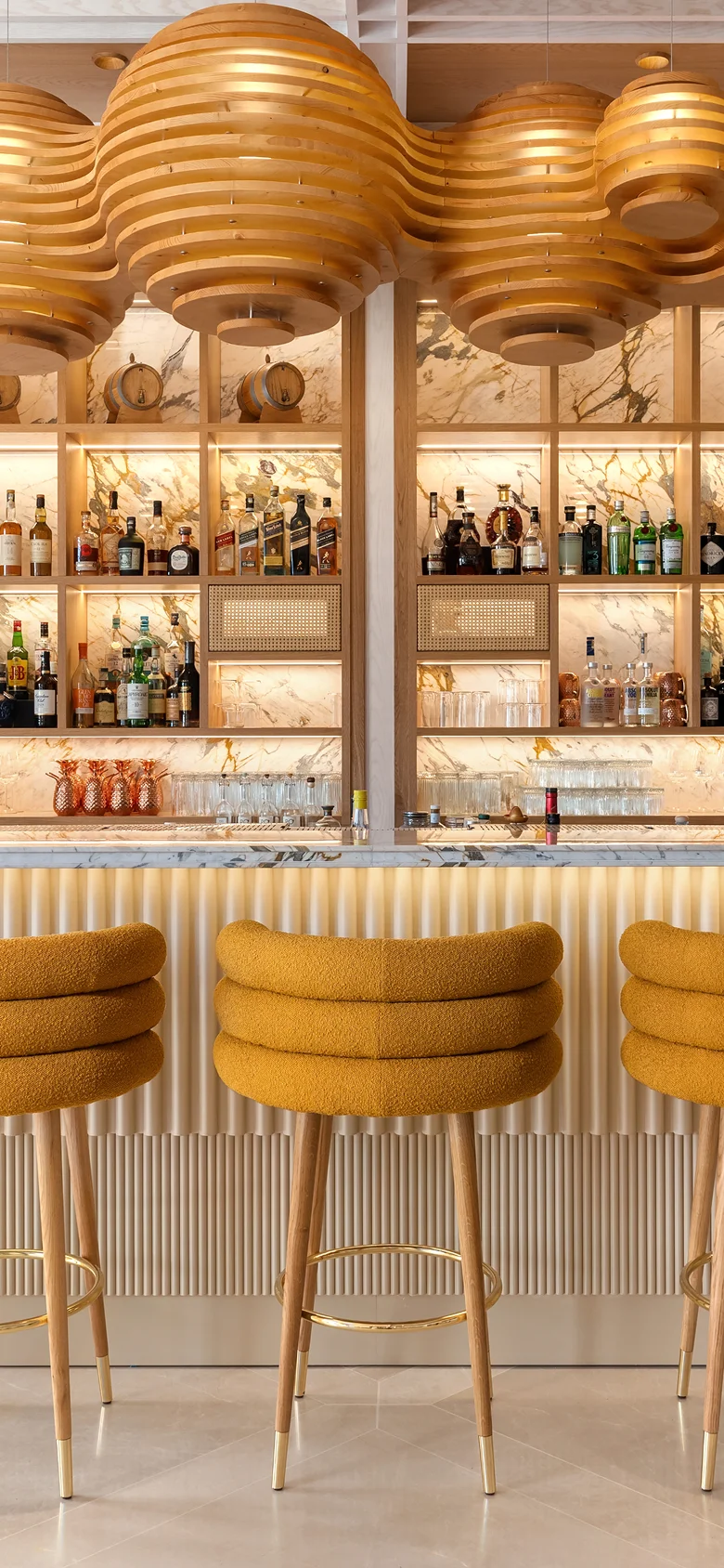 Marshmallow Bar/Counter Stool with three fully upholstered cylindrical rolls, brass cylinder footrest, lacquered or upholstered legs with brass bases, sculptural geometry, tactile comfort, and luxury materials for modern interiors