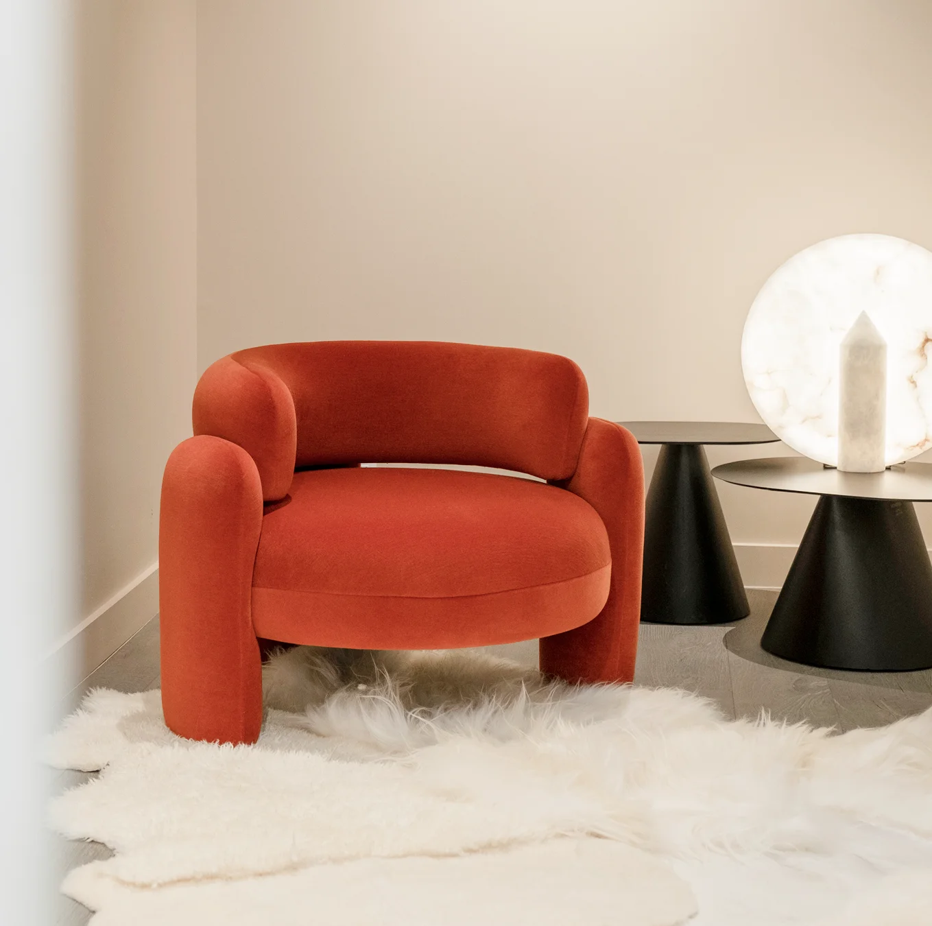 Fully upholstered armchair with rounded backrest, bold geometric curves, and three upholstered legs, elevating modern interiors with elegance and unique style