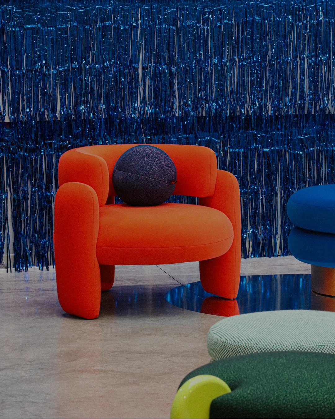 Fully upholstered armchair with rounded backrest, bold geometric curves, and three upholstered legs, elevating modern interiors with elegance and unique style