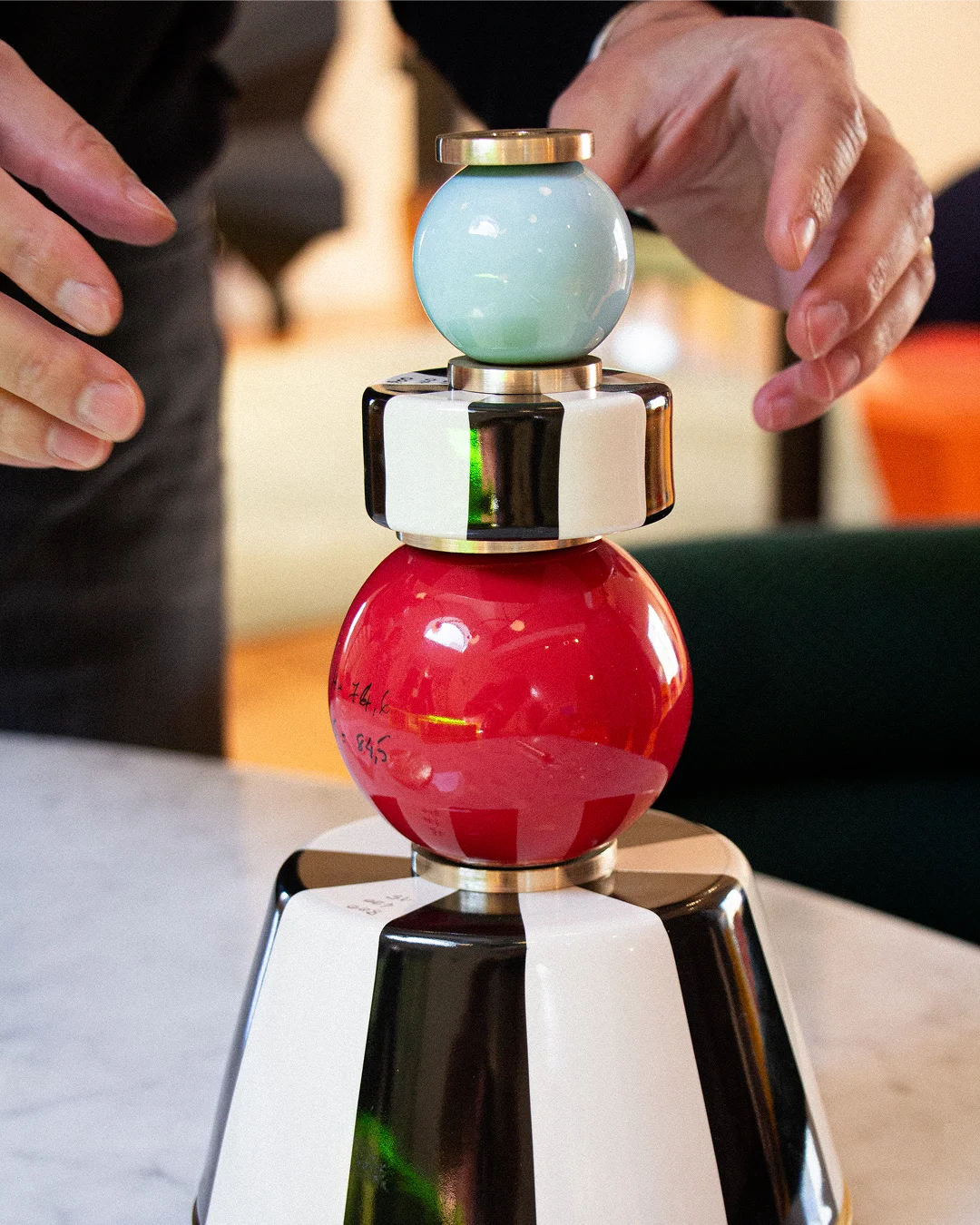 Architectural lighting from the MAAM collection by Royal Stranger, featuring the Valentina floor lamp with its brushed brass structure and hand-applied striped porcelain.