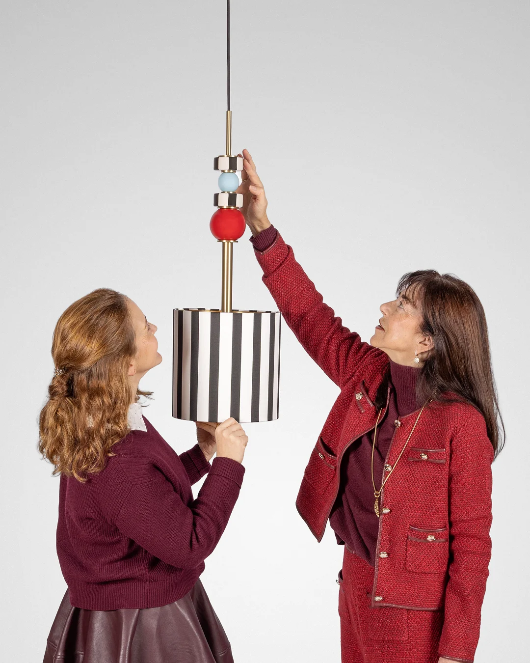 Architectural lighting from the MAAM collection by Royal Stranger, featuring the Valentina floor lamp with its brushed brass structure and hand-applied striped porcelain.