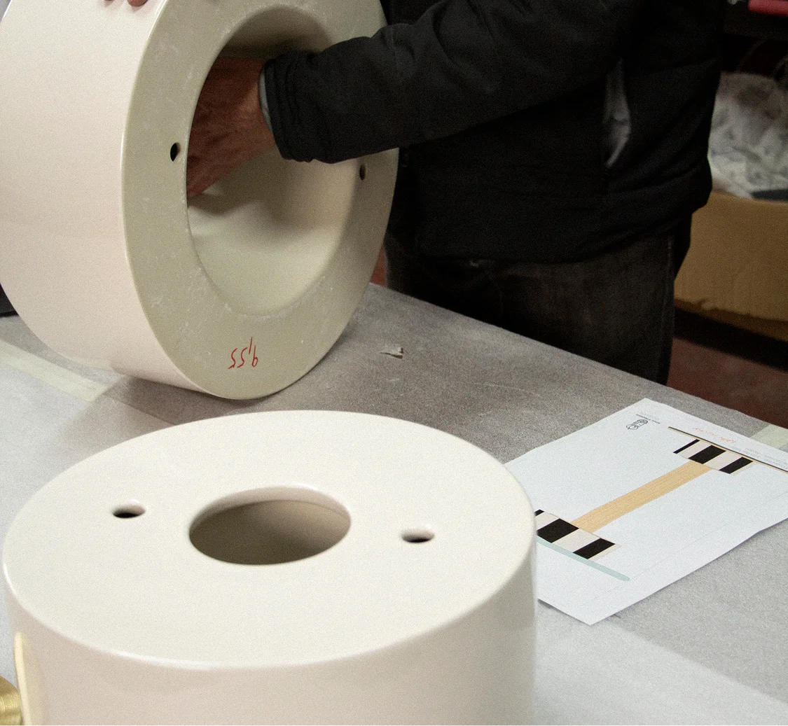 Detailed view of the structural joint and brushed brass backbone of a MAAM collection table, highlighting the stability and study of the assembly.