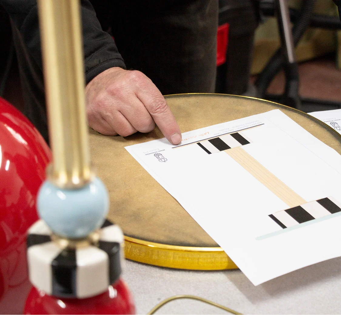 Detailed view of the structural joint and brushed brass backbone of a MAAM collection table, highlighting the stability and study of the assembly.