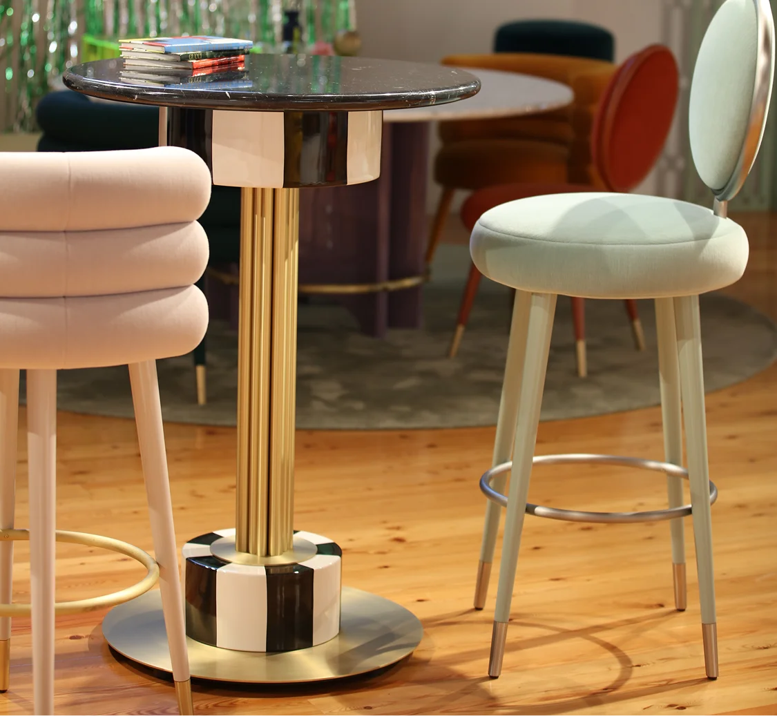 Detailed view of the structural joint and brushed brass backbone of a MAAM collection table, highlighting the stability and study of the assembly.